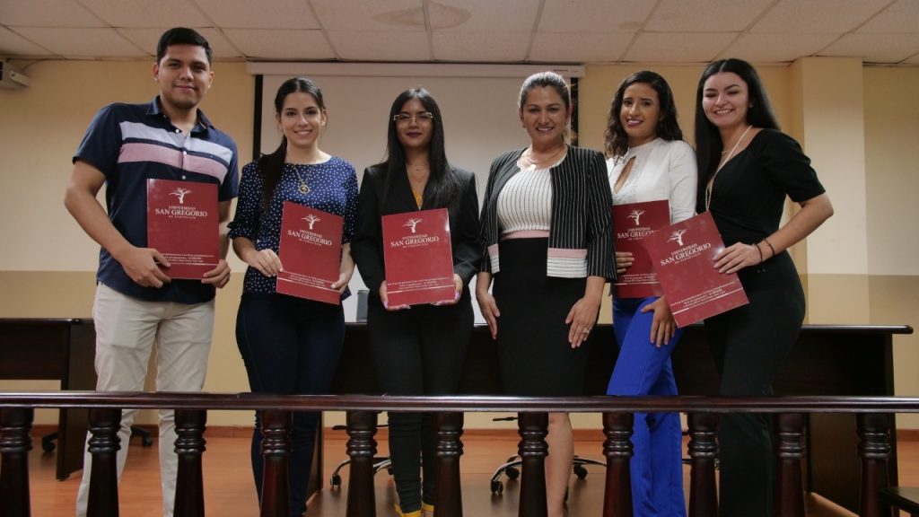 Los estudiantes ganadores junto a la Coordinadora de la Carrera de Derecho.